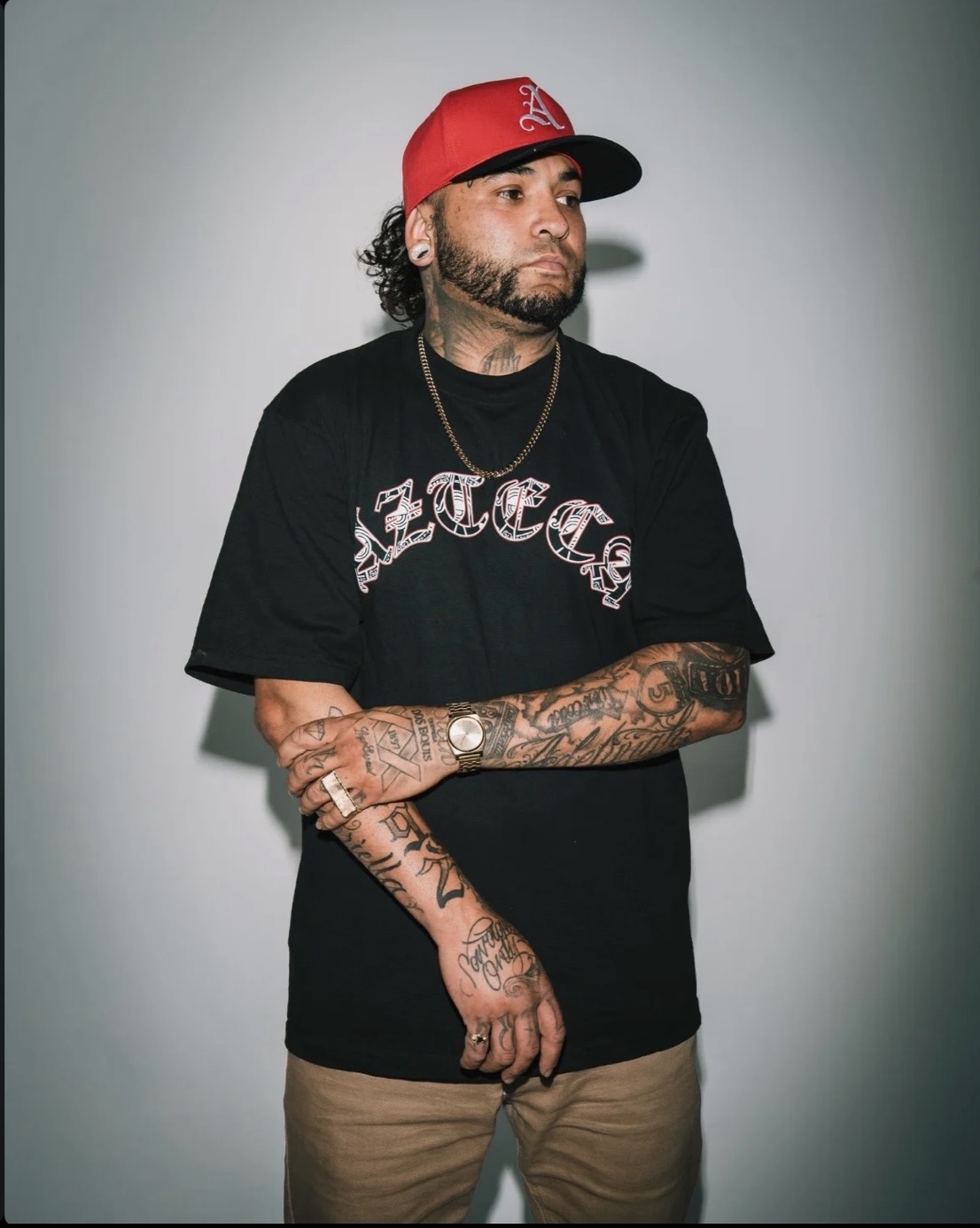 Azteca 19 portrait — red cap, Azteca tee